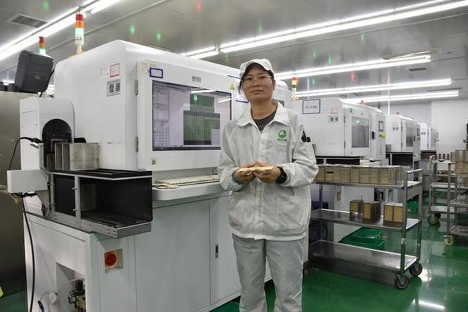 湖南普斯赛特光电科技工人在自动光学检测设备前展示led灯珠